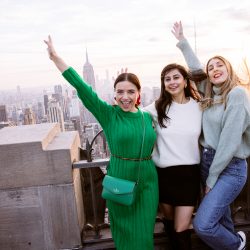 Three women posing at Top of the Rock in New York