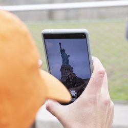 Guide taking a photo of Statue of Liberty