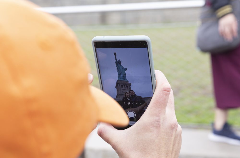 Guide taking a photo of Statue of Liberty