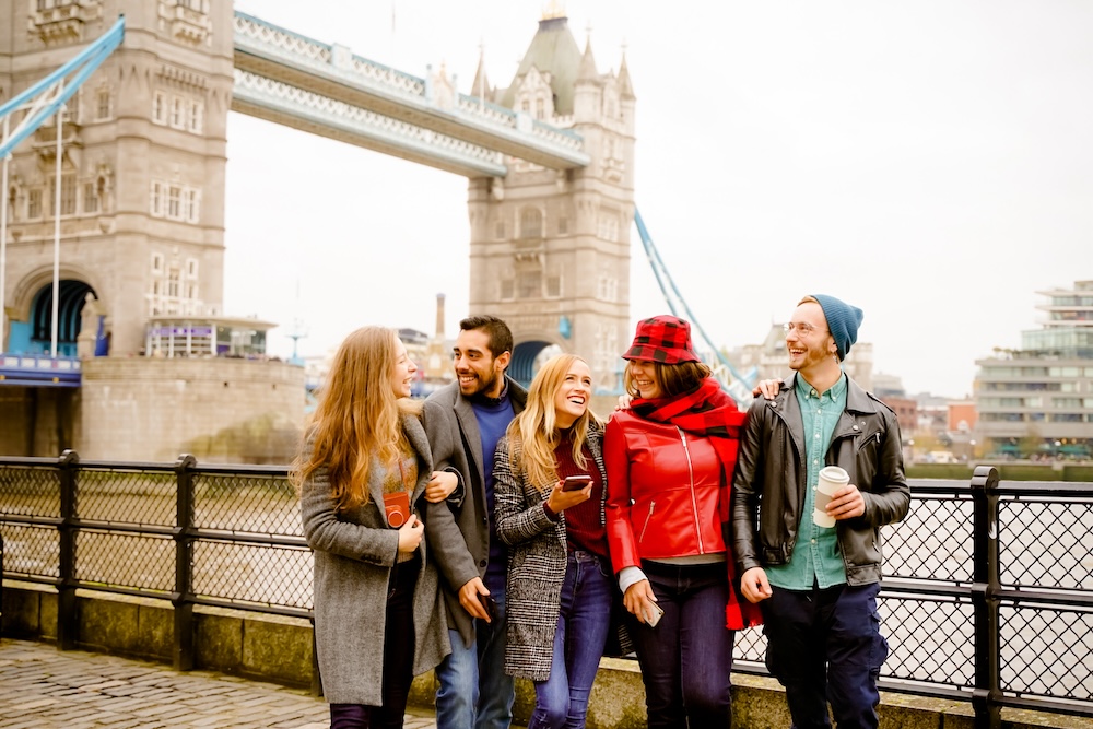 Friends smiling at Tower Bridge