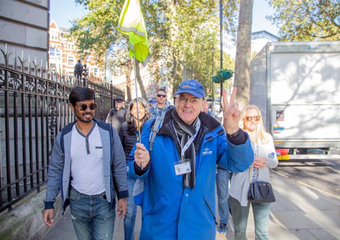 Tour guide leading travelers through on a London tour