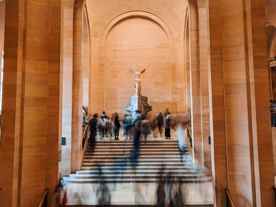 People on stairway in the Louvre near winged victory of samothrace statue