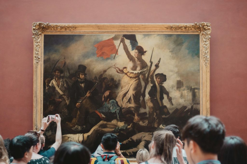 Tourists in front of artwork at Louvre Museum