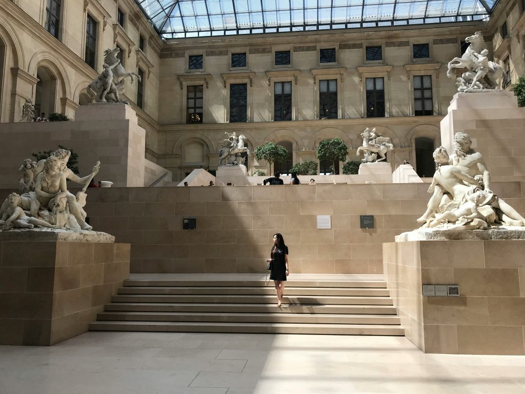 
woman standing on stairs in front of museum