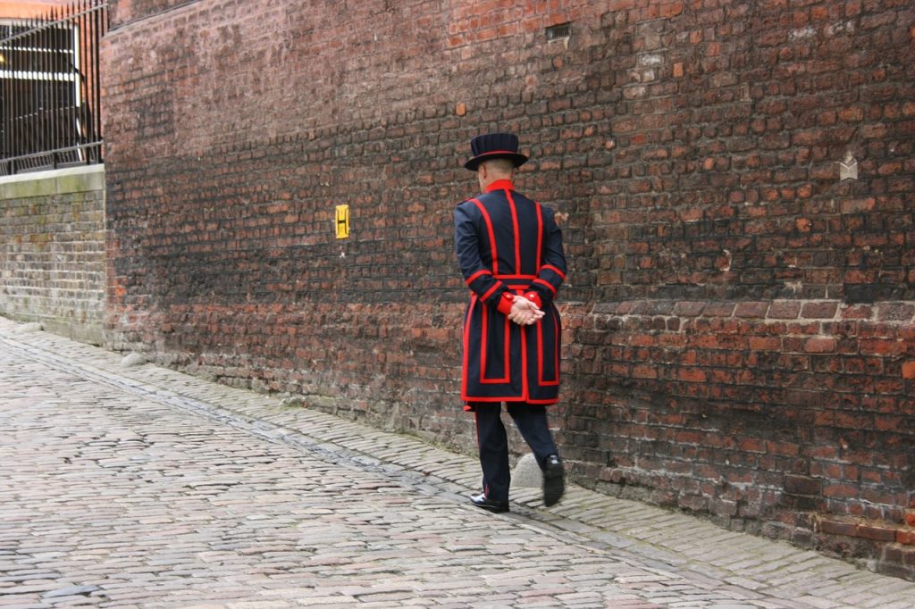 Back shot of beefeater walking near the Tower of London