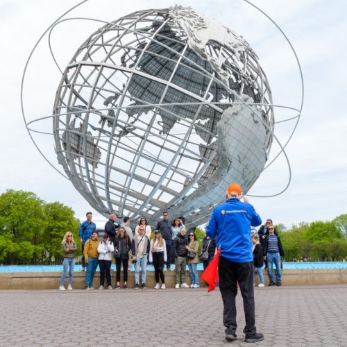 Tour guide taking a photo of the Unisphere on an NYC bus tour