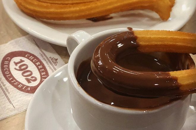 Churro dipped in chocolate at Churros and hot chocolate at Chocolatería 1902