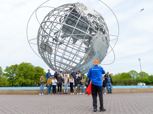 Group shot with guide taking the photo at Unisphere in Brooklyn, Bronx, Queens Tour