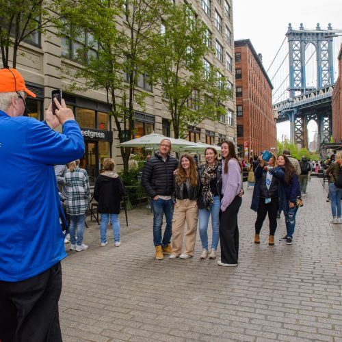 Tour guide taking photo of guests in Brooklyn, Bronx, Queens Bus Tour