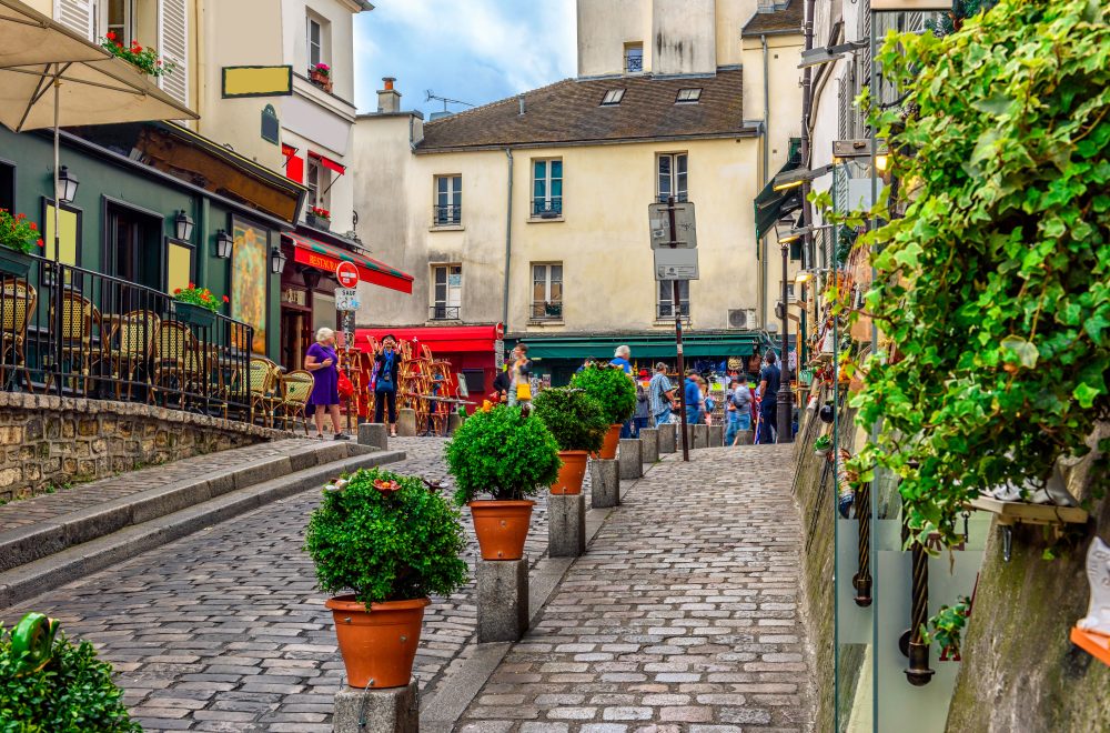 Cozy street with tables of cafe in quarter Montmartre in Paris, France