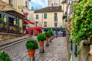 Cozy street with tables of cafe in quarter Montmartre in Paris, France