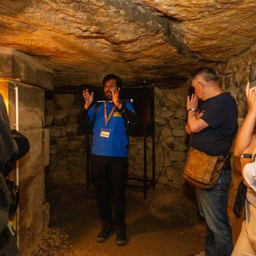 Guide explaining through tombs during Catacombs Guided Tour