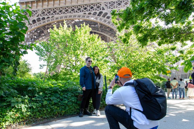 Eiffel Tower tour guide takes a photo of travelers