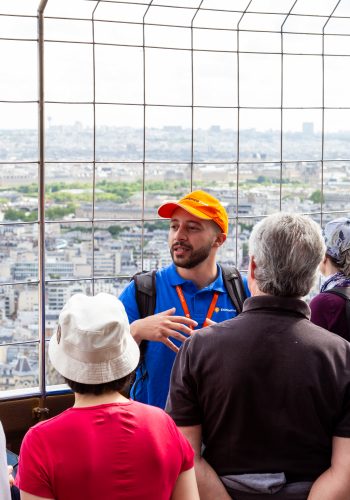 Tour Guide explaining during Eiffel Tower Guided Climb with scenic background view