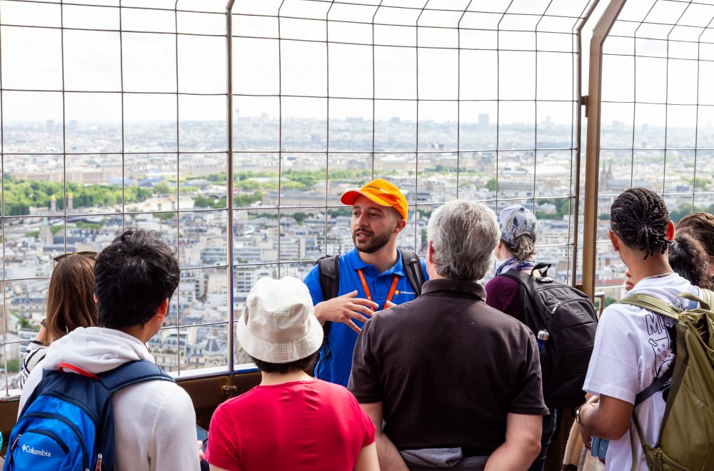 Guests on Eiffel Tower tour listen to tour guide