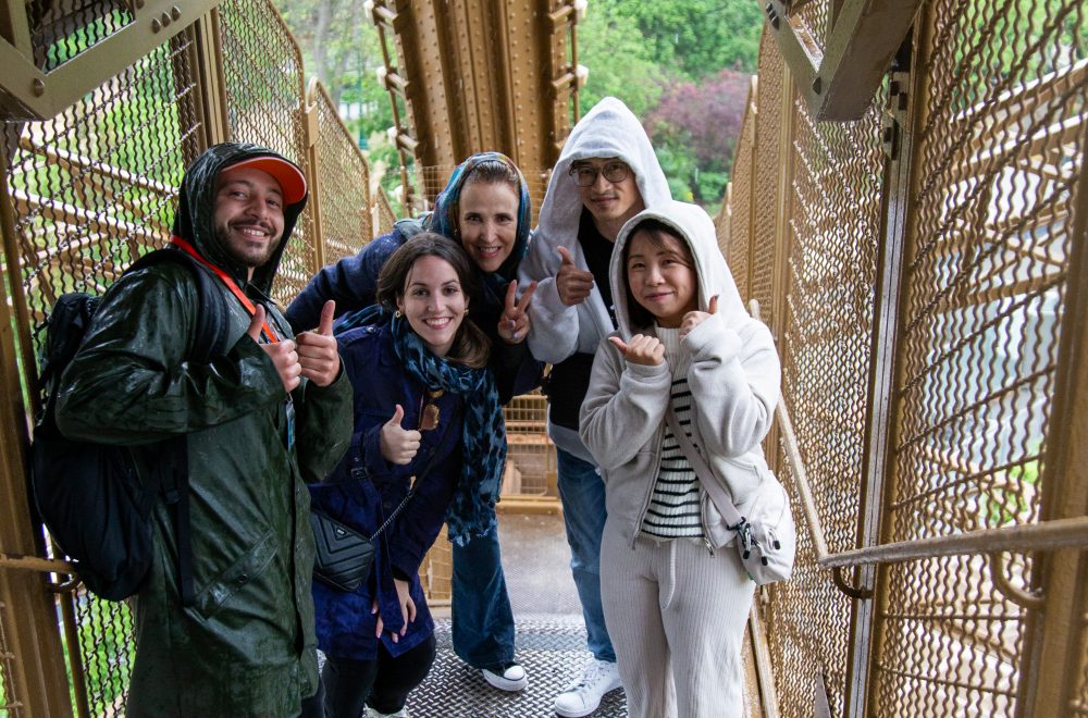 Tour guide and group posing during the Eiffel Tower Guided Climb