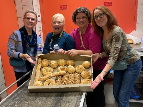 Guests posing with tray of freshly baked bread