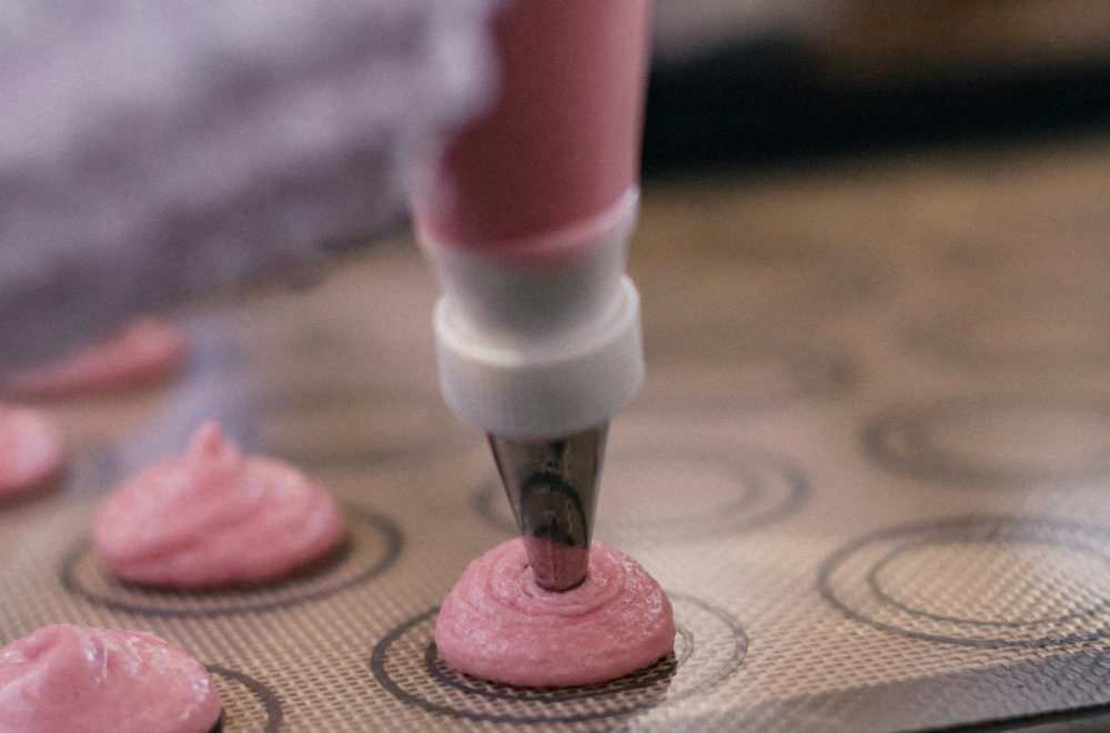 Piping macaron shells during Paris Macaron Baking Class