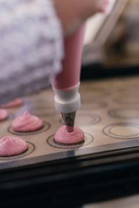 Piping macaron shells during Paris Macaron Baking Class