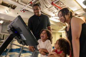 Family interacting with an exhibit at the USS Midway Museum in San Diego