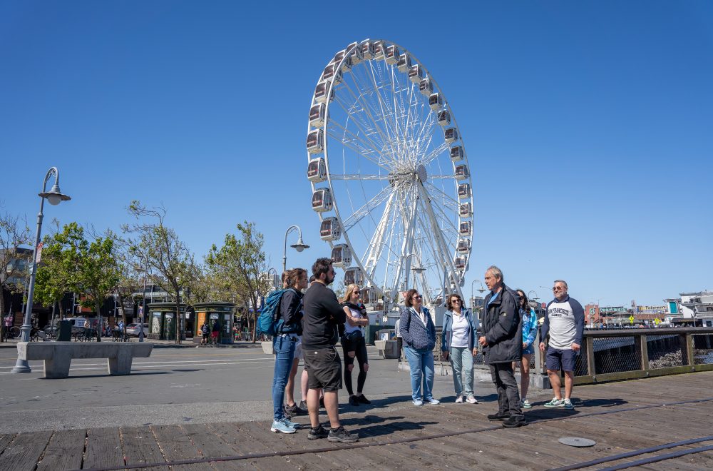 Group and tour guide near Ferris Wheel during Fisherman_s Wharf guided tour