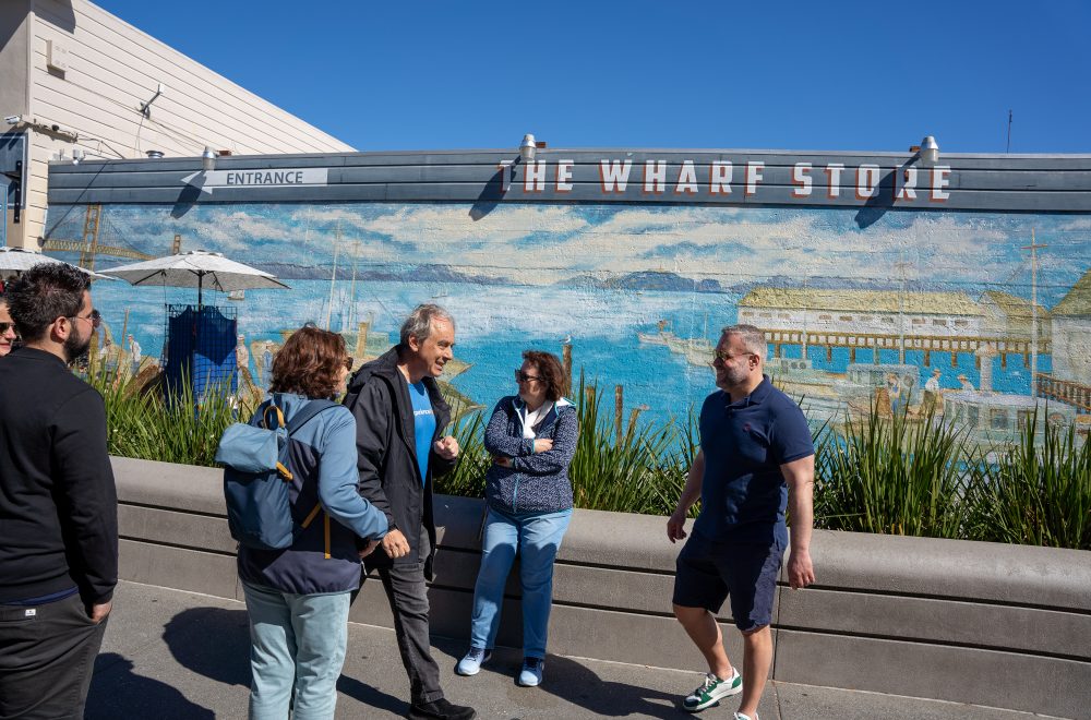 Tour guide and guests in front of the Wharf Store in San Francisco