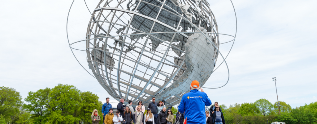Group shot with guide taking the photo at Unisphere in Brooklyn, Bronx, Queens Tour