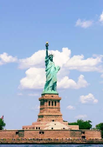 Tourists looking at Statue of Liberty from ferry